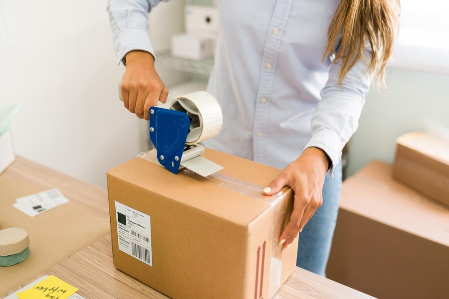 propietario negocio listo enviar pedidos sus clientes primer plano manos femeninas poniendo cinta adhesiva paquete grande productos 662251 1920